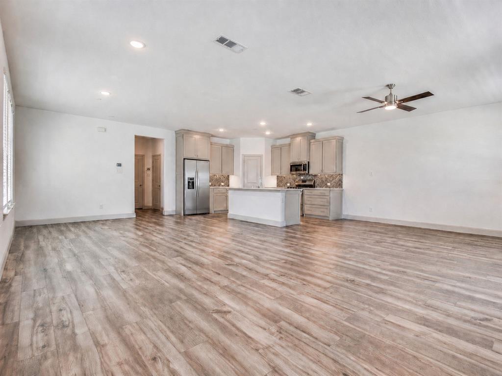 8913 Swallowtail Street Frisco, TX 75035 - Photo 6 of 38 a view of a kitchen with a sink and a refrigerator