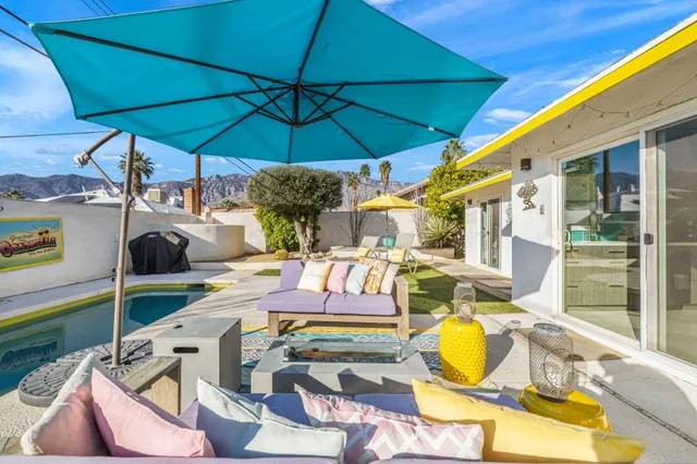 a view of a patio with table and chairs under an umbrella