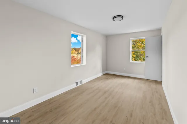 an empty room with windows and closet