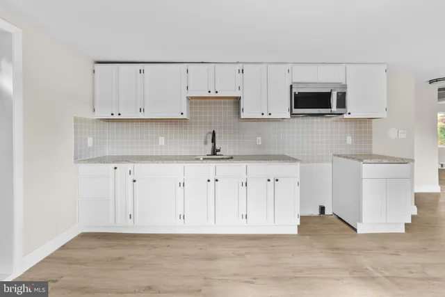 a view of kitchen with granite countertop stainless steel appliances a sink and a counter space