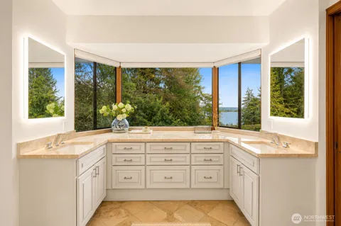 a bathroom with a granite countertop sink and a large mirror