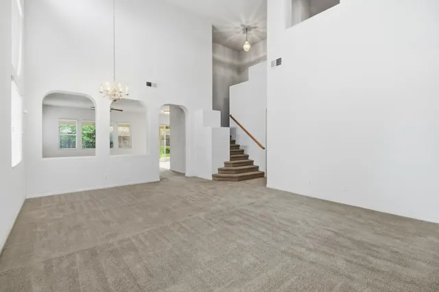 a large kitchen with a large counter top a sink stainless steel appliances and cabinets