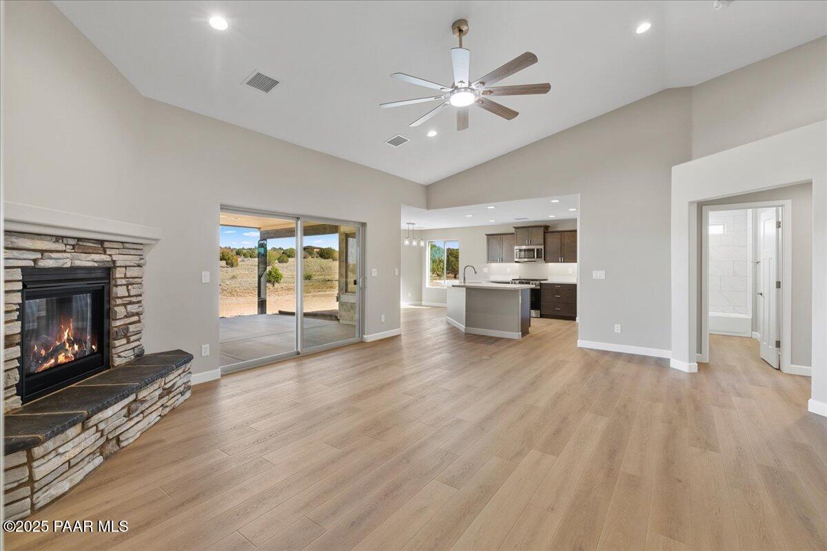 1220 East Cougar Ridge Road Paulden, AZ 86334 - Photo 3 of 30 an empty room with windows fireplace and wooden floor