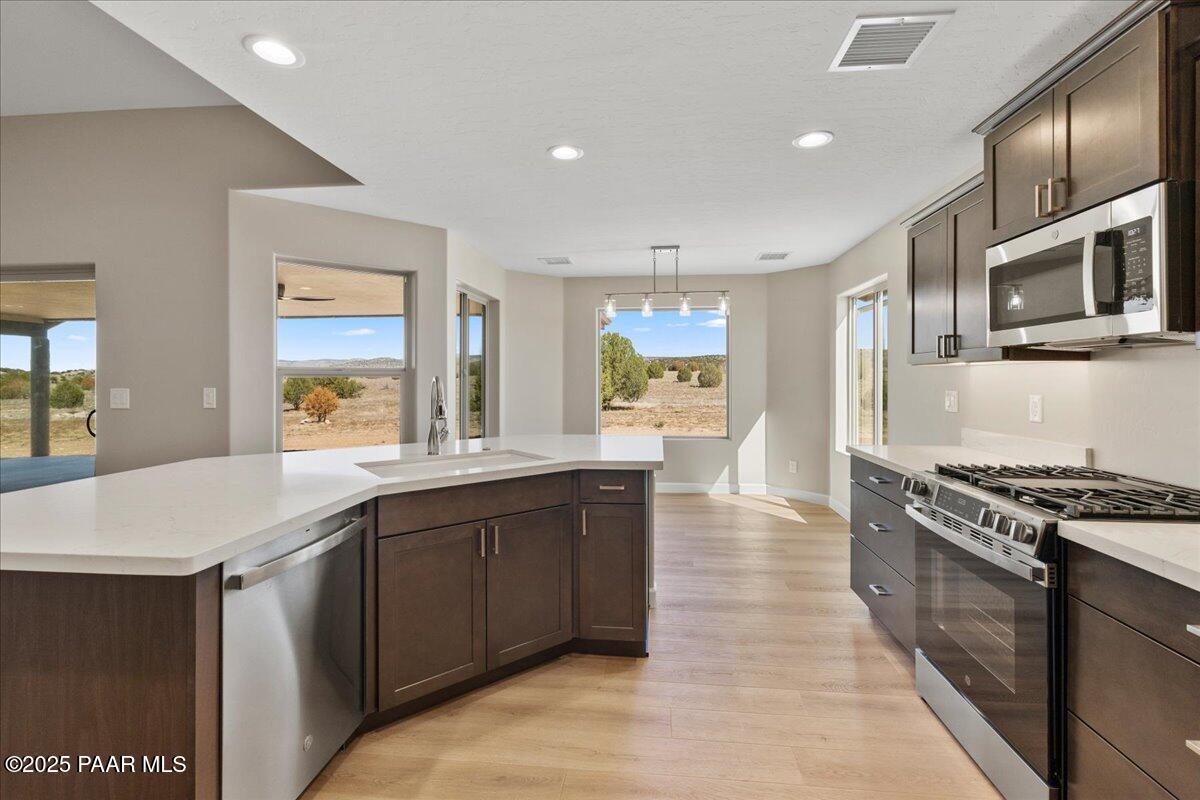 1220 East Cougar Ridge Road Paulden, AZ 86334 - Photo 8 of 30 a kitchen with stainless steel appliances granite countertop a stove a sink and a microwave