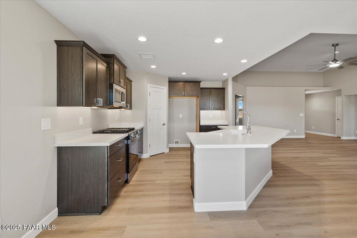 1220 East Cougar Ridge Road Paulden, AZ 86334 - Photo 9 of 30 a large white kitchen with a large counter top space and stainless steel appliances
