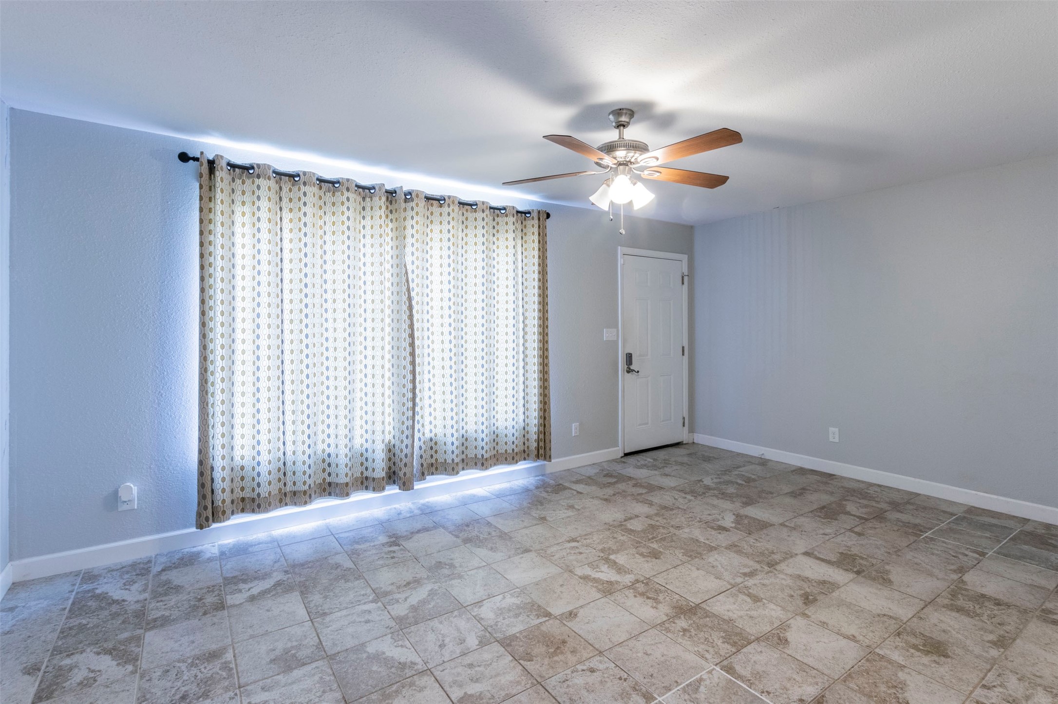2903 Rogge Lane Austin, TX 78723 - Photo 4 of 26 an empty room with windows and fan