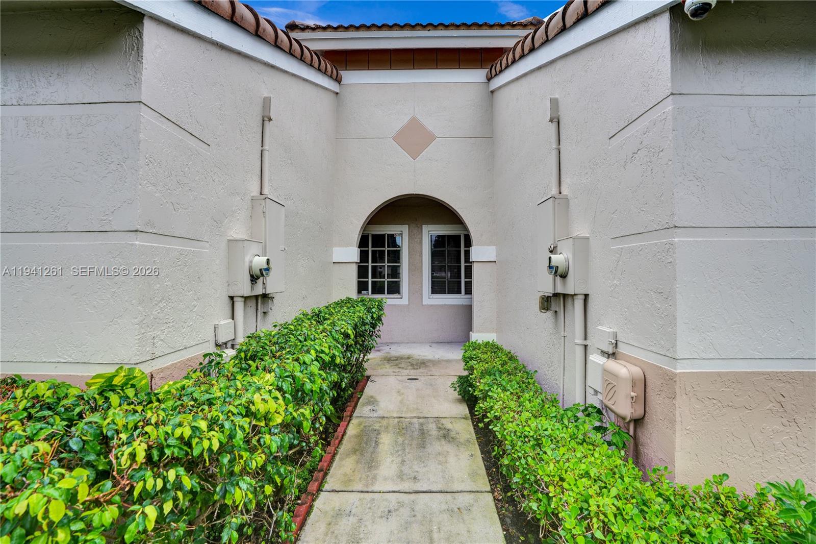 1851 Southwest 116th Way Miramar, FL 33025 - Photo 26 of 30 a view of a pathway of a house with potted plants