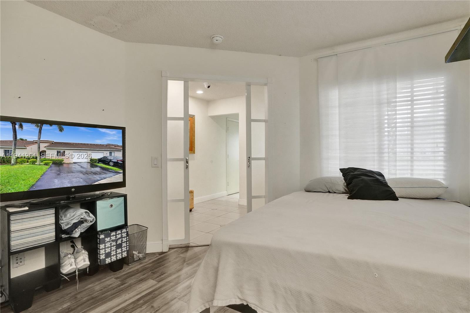 1851 Southwest 116th Way Miramar, FL 33025 - Photo 7 of 30 a bedroom with a bed windows and a chandelier