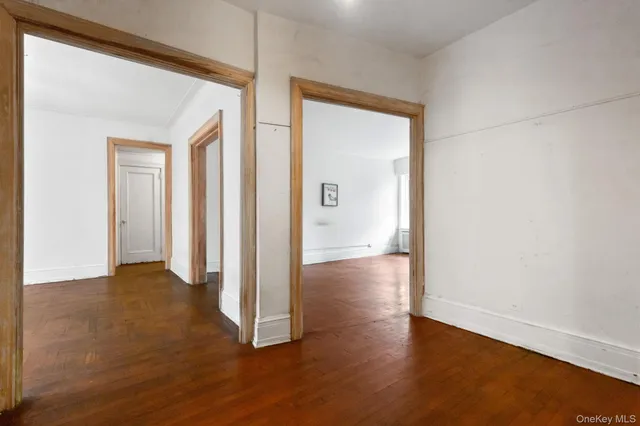 an empty room with wooden floor and a window