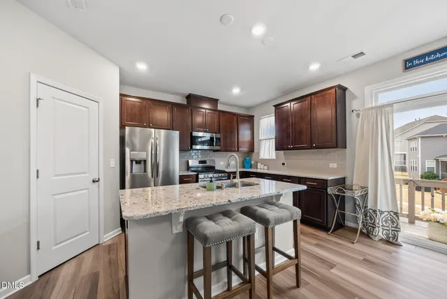 a kitchen with stainless steel appliances kitchen island granite countertop a refrigerator and microwave