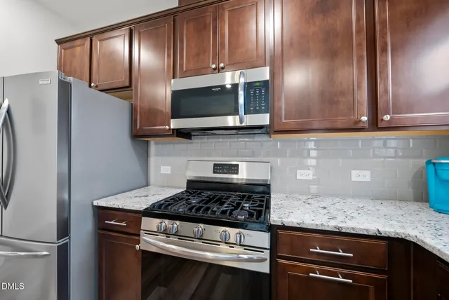 a kitchen with granite countertop wooden cabinets and stainless steel appliances