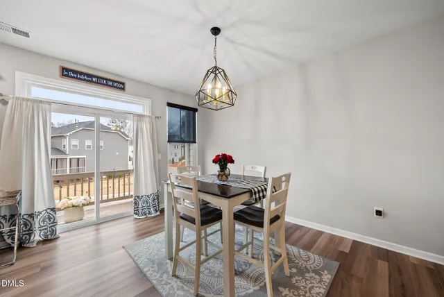 a view of a dining room with furniture wooden floor and chandelier
