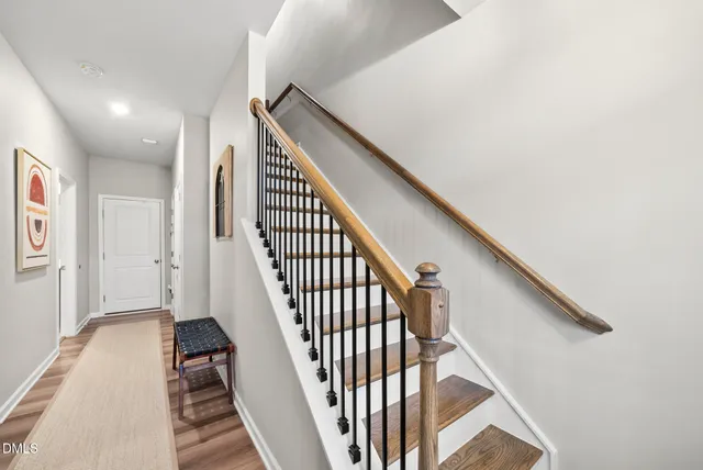 a view of staircase with wooden floor and white walls