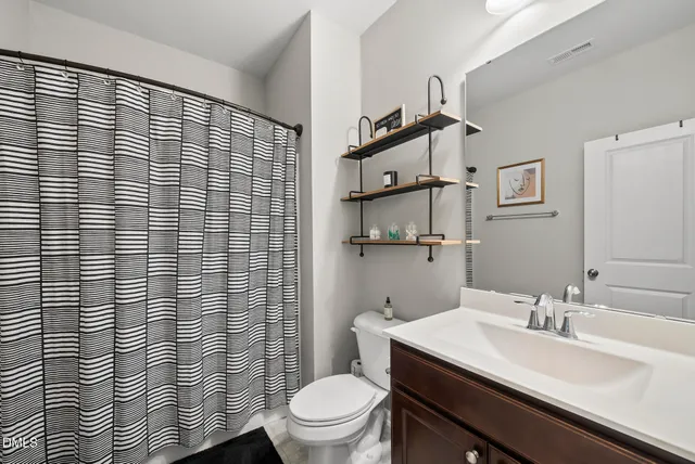 a bathroom with a sink a toilet and shower curtain