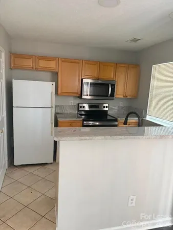 a kitchen with a refrigerator and a stove top oven