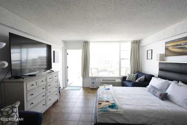 a spacious bedroom with a large bed and a flat screen tv