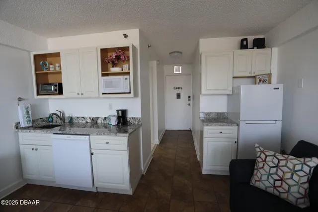 a kitchen with stainless steel appliances kitchen island granite countertop a refrigerator and a stove top oven