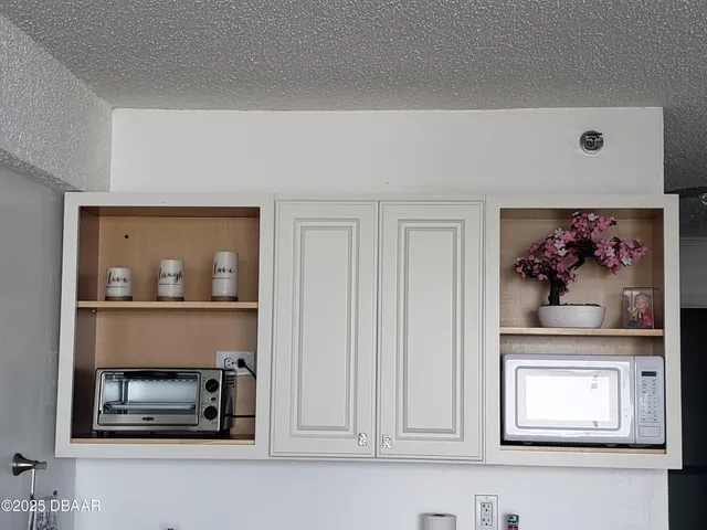 a living room with painting on the wall and a potted plant