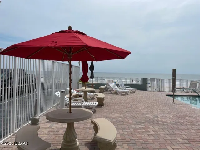 a view of a tables and chairs under an umbrella in patio