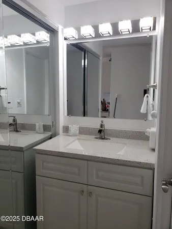 a bathroom with a sink vanity and a mirror