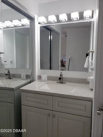 a bathroom with a sink vanity and a mirror