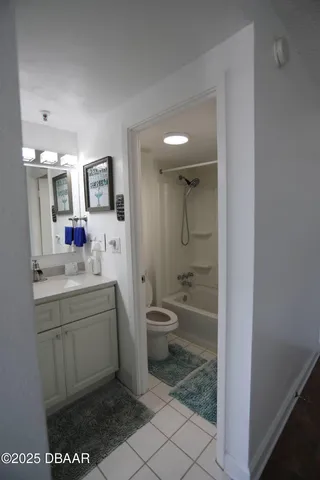 a bathroom with a granite countertop sink mirror vanity and toilet