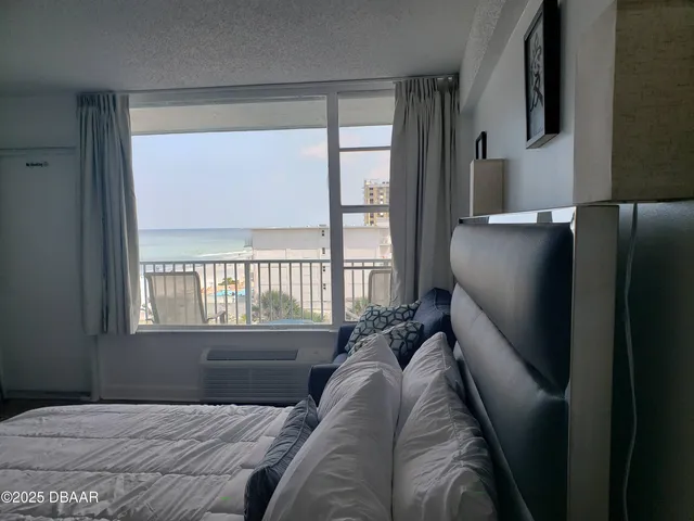 a bedroom with a bed next to a window