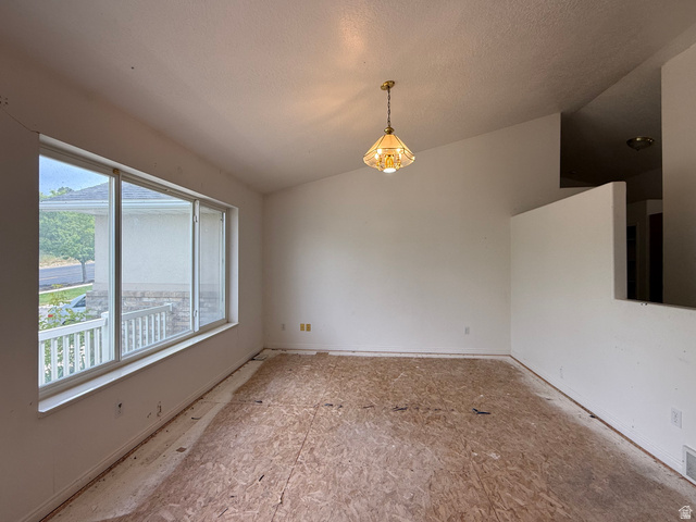 838 East Mountain Road Logan, UT 84321 - Photo 4 of 37 Interior room with unfinished subfloor, a large window, vaulted ceiling, and a hanging pendant light fixture