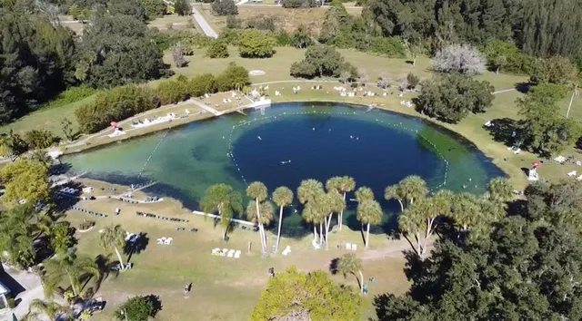 an aerial view of a house a yard and mountain view in back
