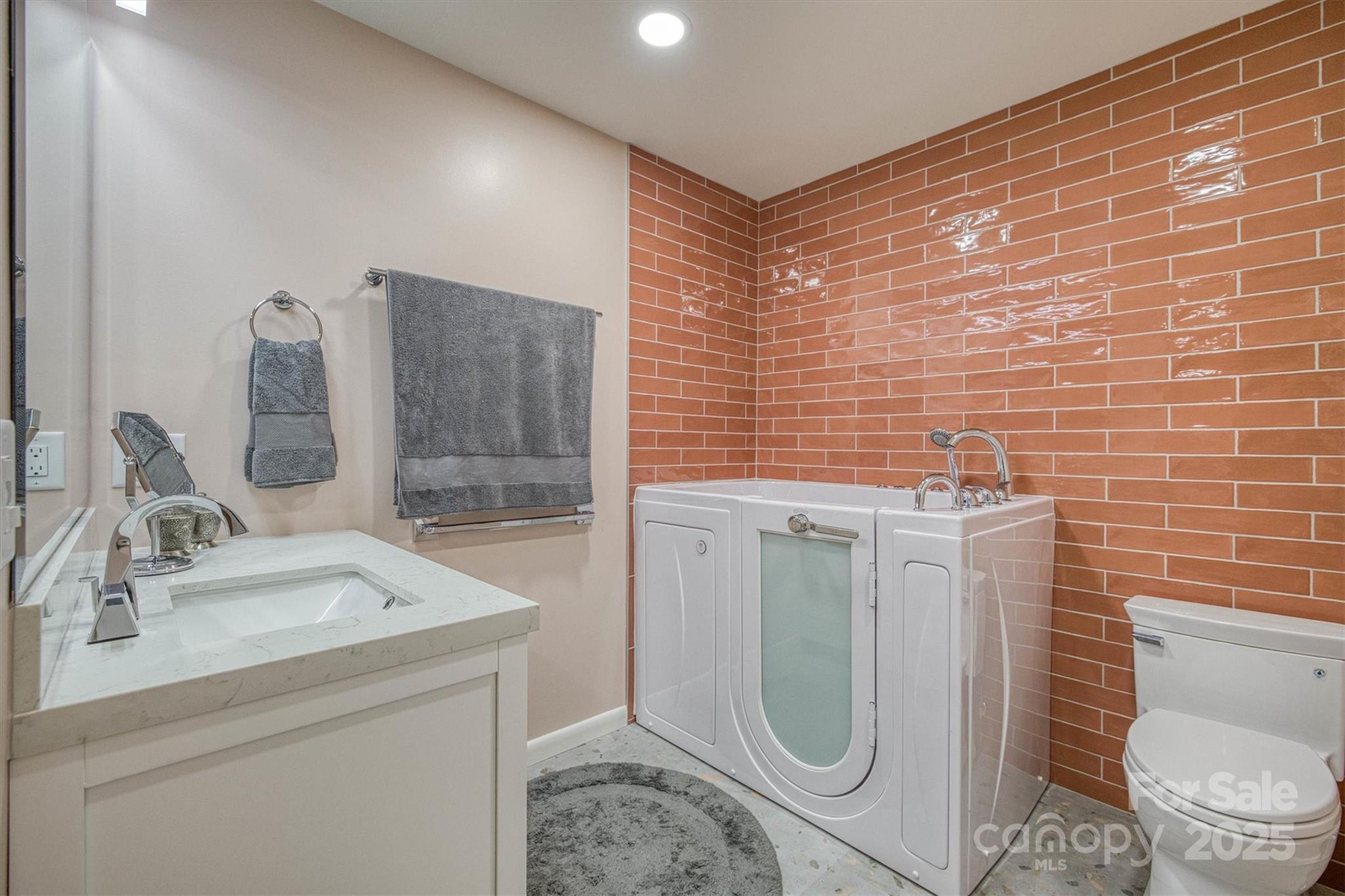 214 Howard Street Morganton, NC 28655 - Photo 19 of 29 a bathroom with a granite countertop toilet sink and mirror