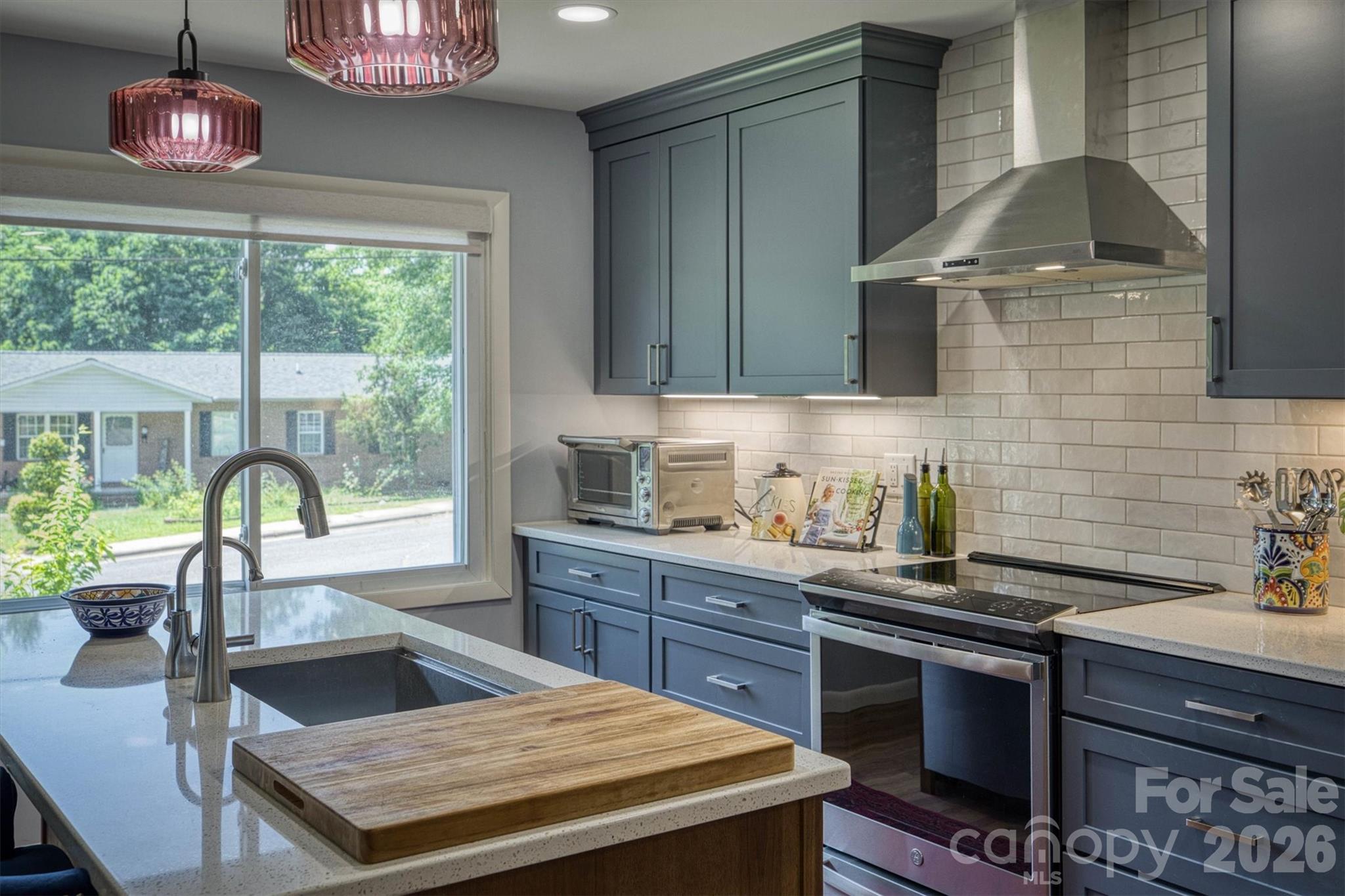 214 Howard Street Morganton, NC 28655 - Photo 8 of 22 a kitchen with a stove a sink and a wooden cabinets