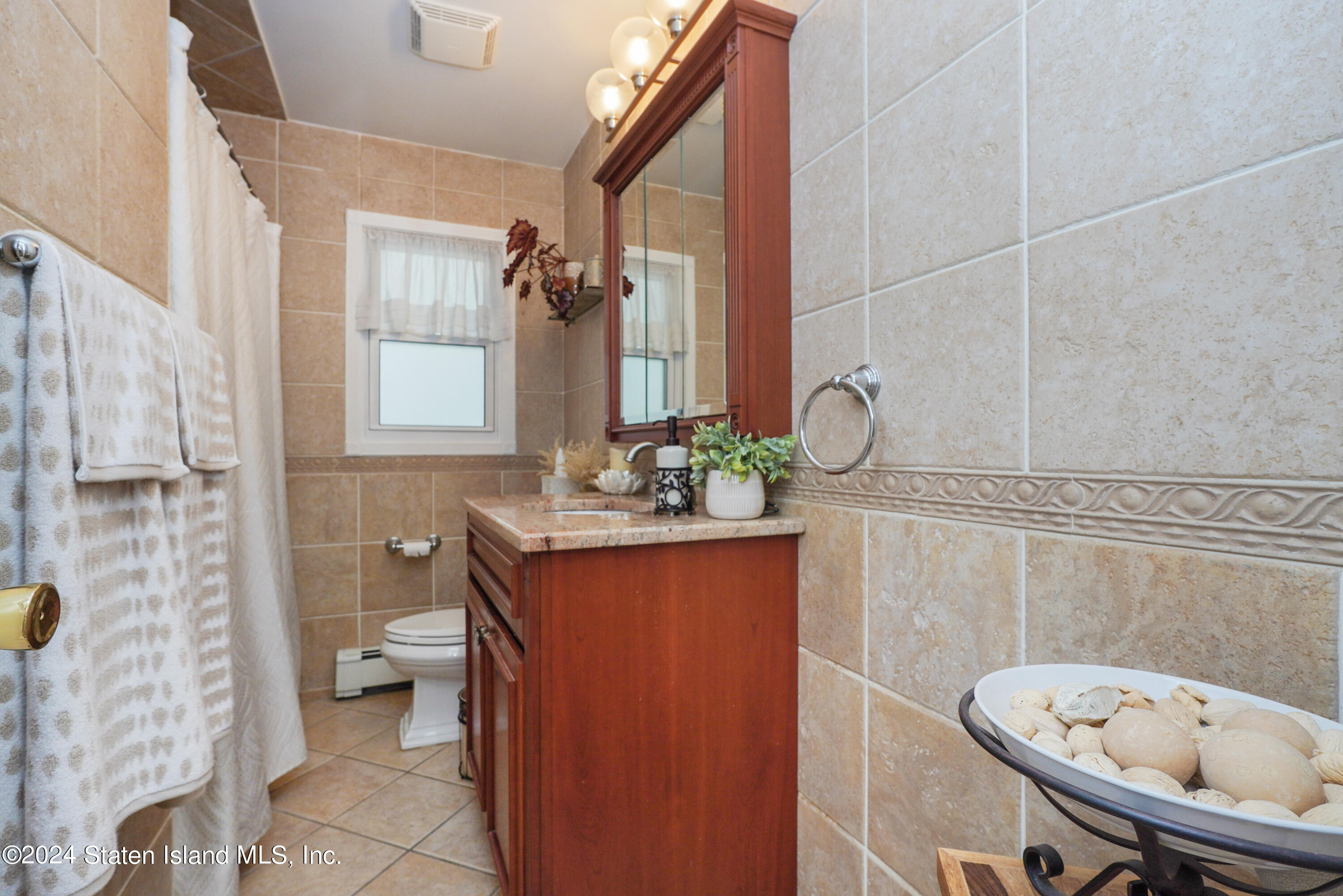 50 Ridgecrest Avenue Staten Island, NY 10312 - Photo 15 of 34 a bathroom with a granite countertop sink a toilet a mirror and shower