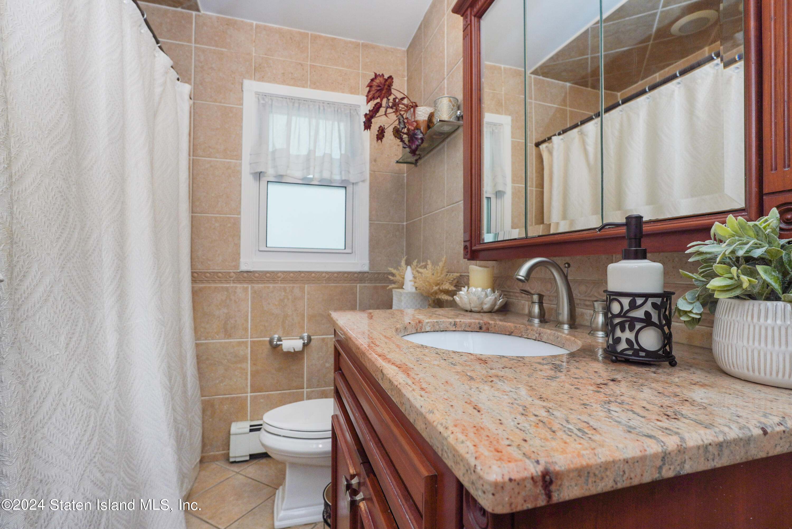 50 Ridgecrest Avenue Staten Island, NY 10312 - Photo 16 of 34 a bathroom with a granite countertop sink a toilet and a mirror