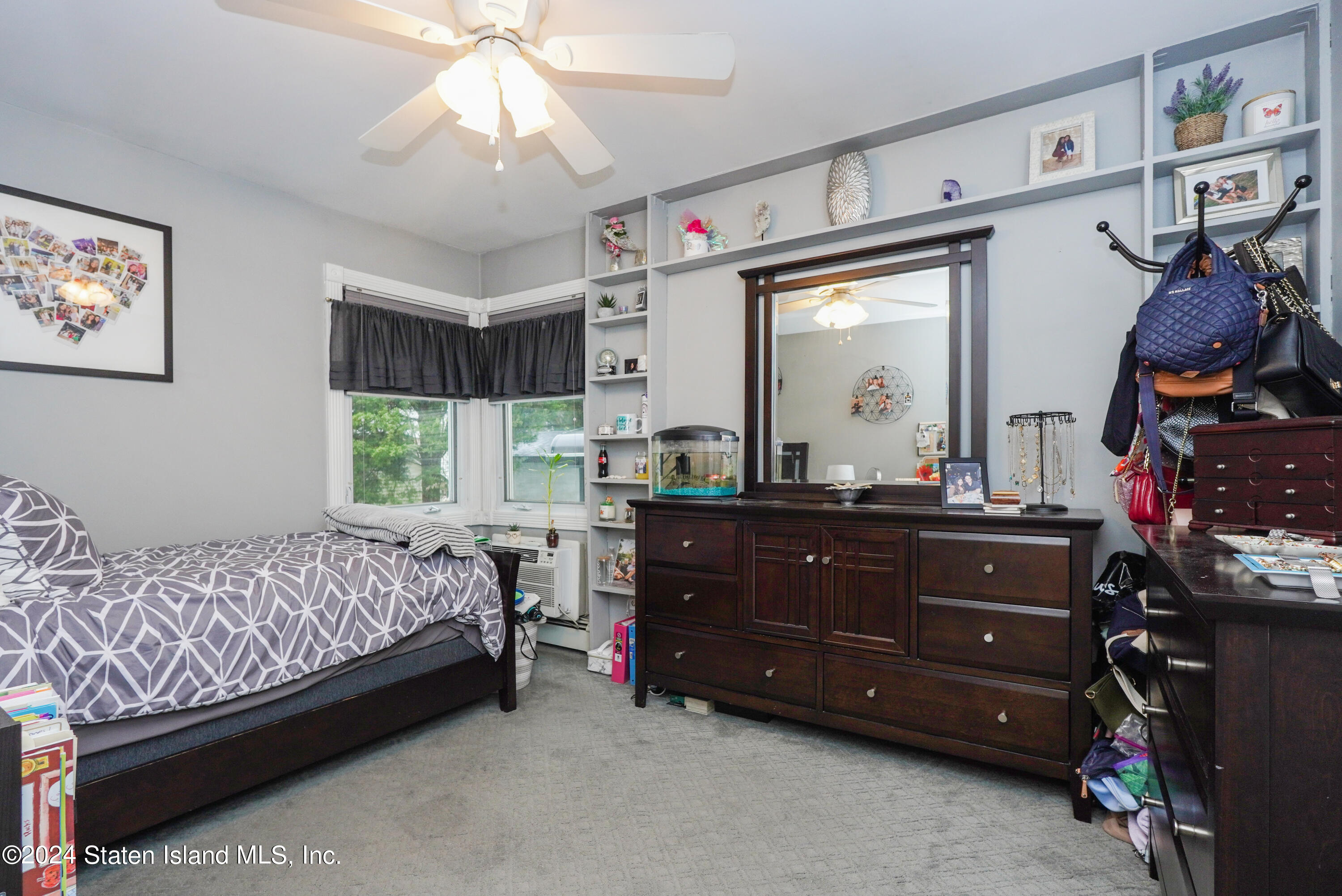 50 Ridgecrest Avenue Staten Island, NY 10312 - Photo 17 of 34 a room with a bed and a mirror on the dresser