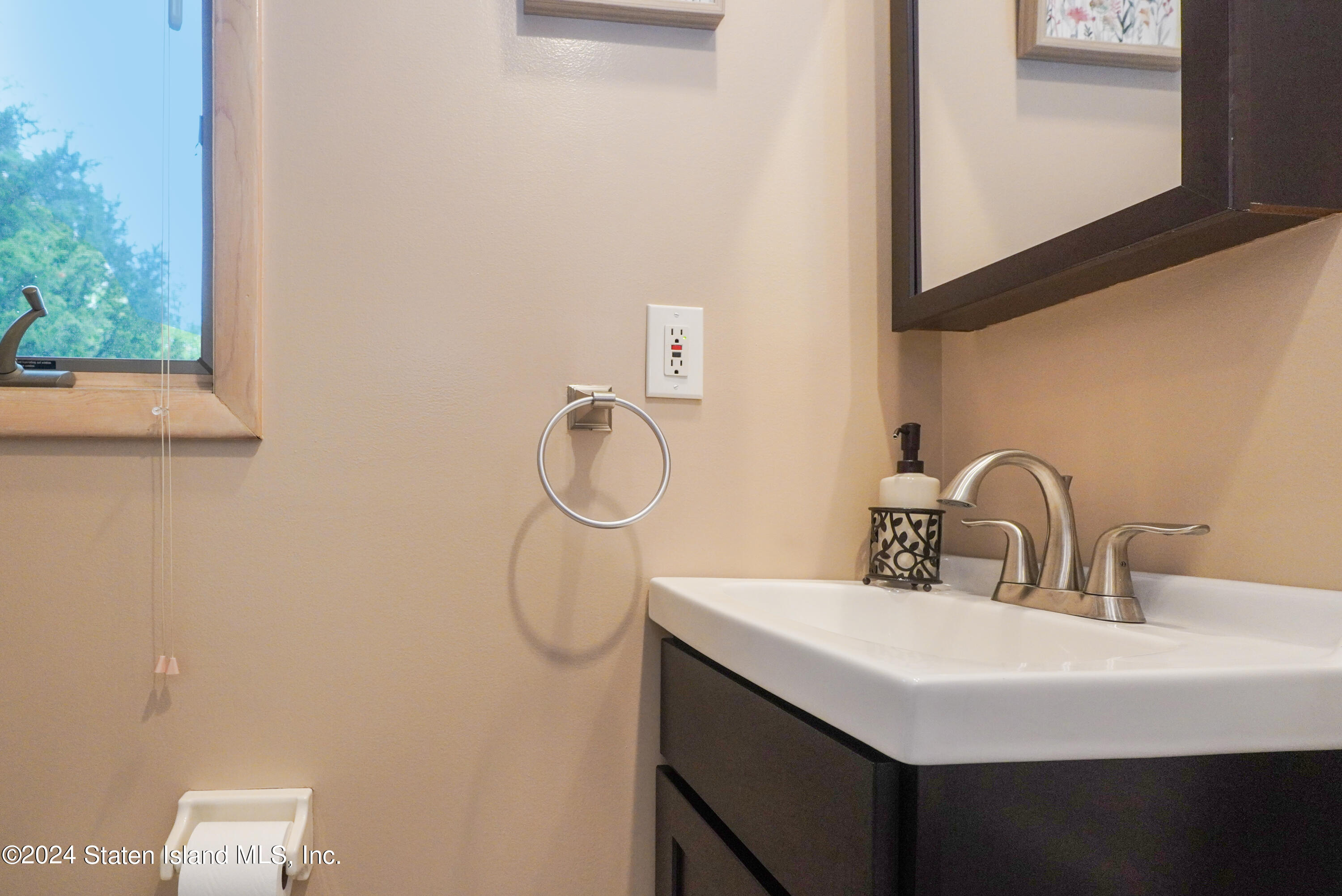 50 Ridgecrest Avenue Staten Island, NY 10312 - Photo 22 of 34 a bathroom with a sink and a mirror