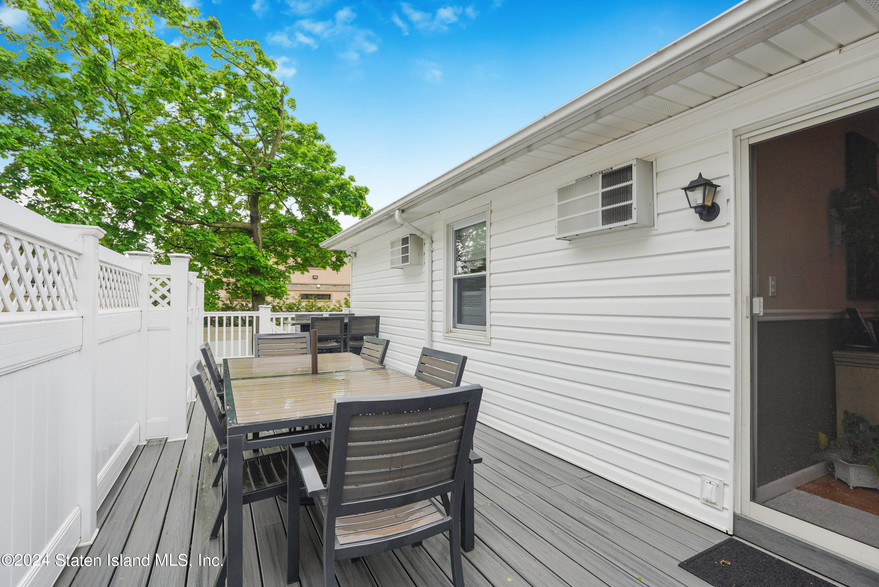 50 Ridgecrest Avenue Staten Island, NY 10312 - Photo 31 of 34 a view of a patio with table and chairs with wooden floor and fence