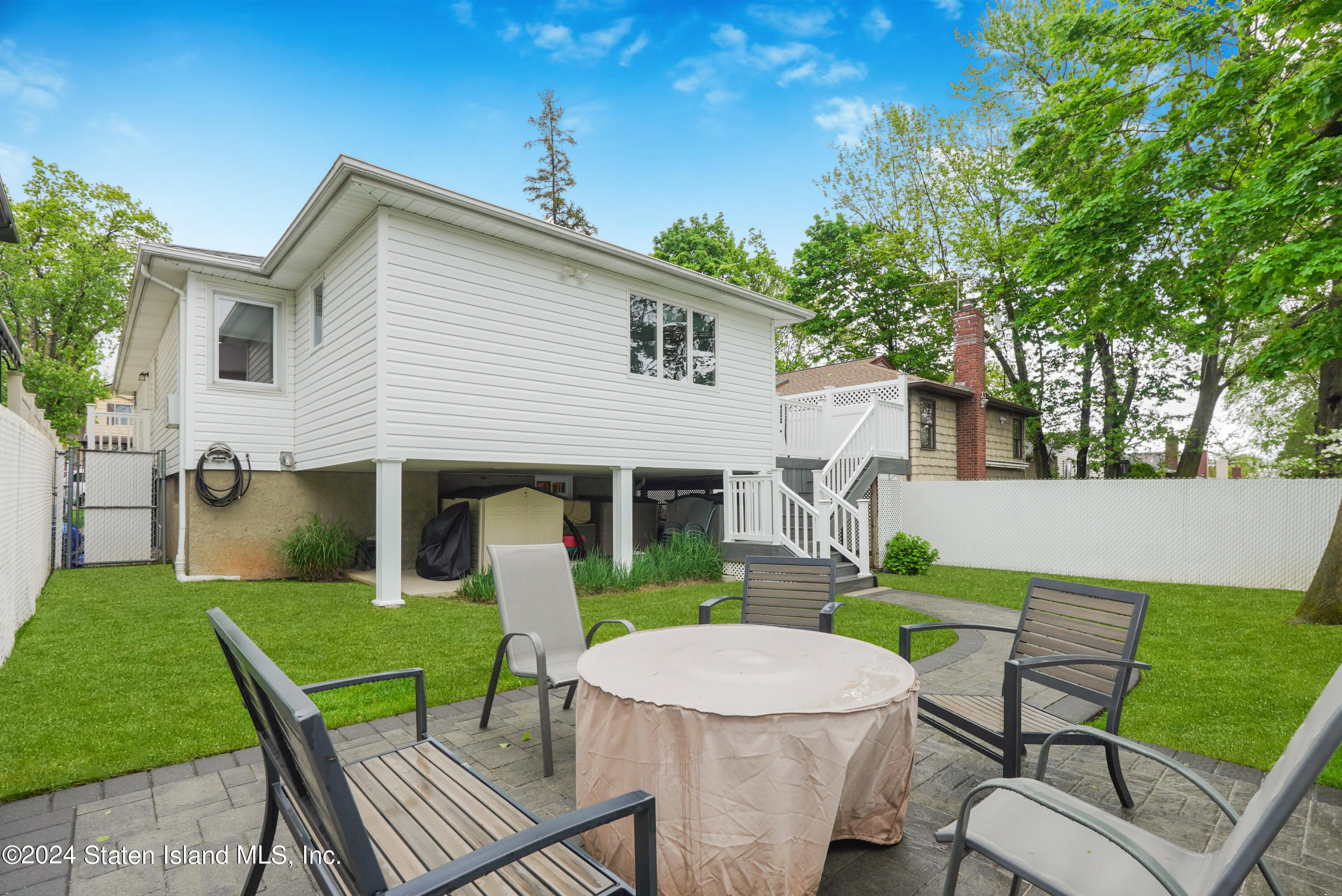 50 Ridgecrest Avenue Staten Island, NY 10312 - Photo 34 of 34 a view of a patio with table and chairs with wooden fence and plants