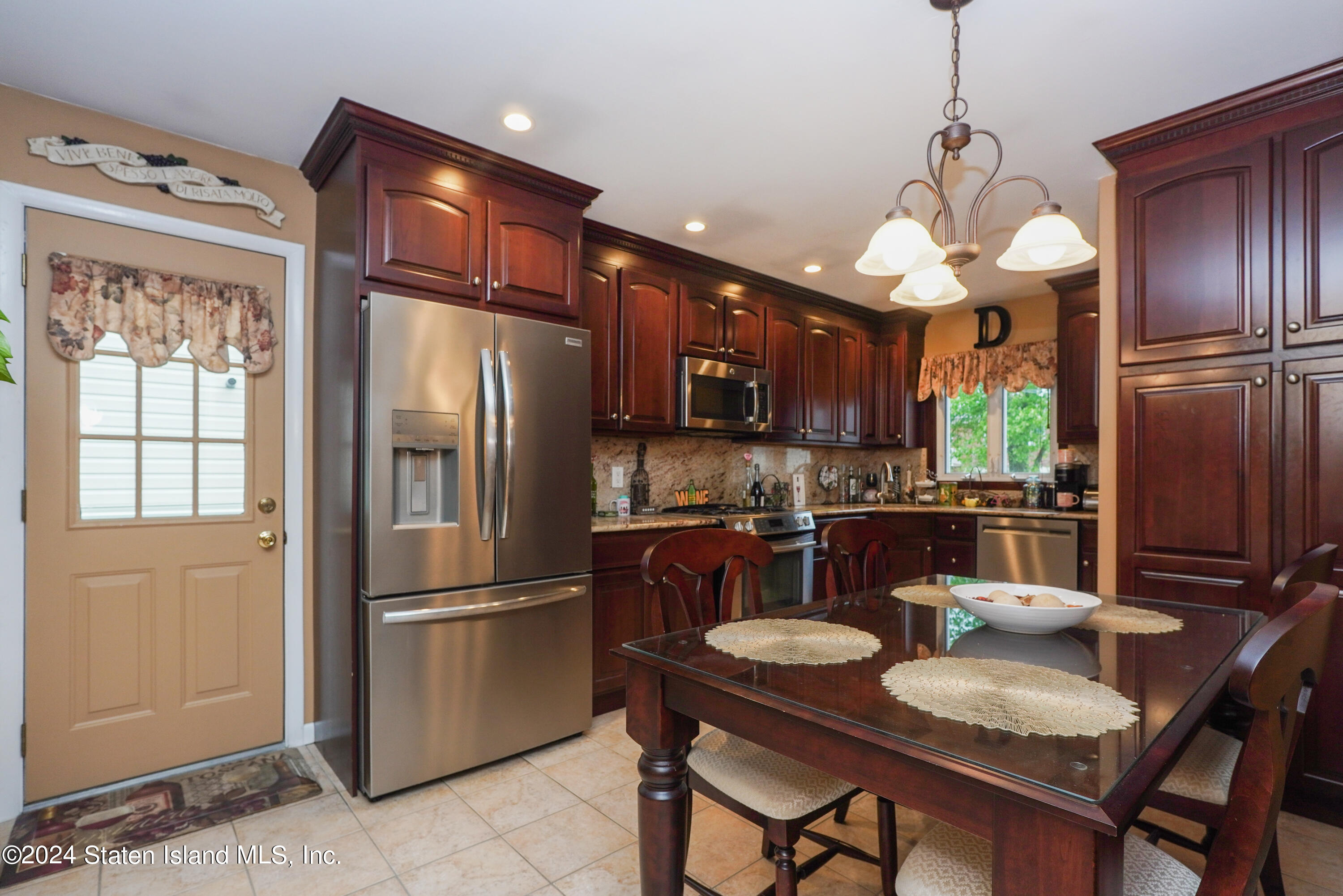 50 Ridgecrest Avenue Staten Island, NY 10312 - Photo 8 of 34 a kitchen with stainless steel appliances granite countertop a refrigerator a sink dishwasher a dining table and chairs with wooden floor