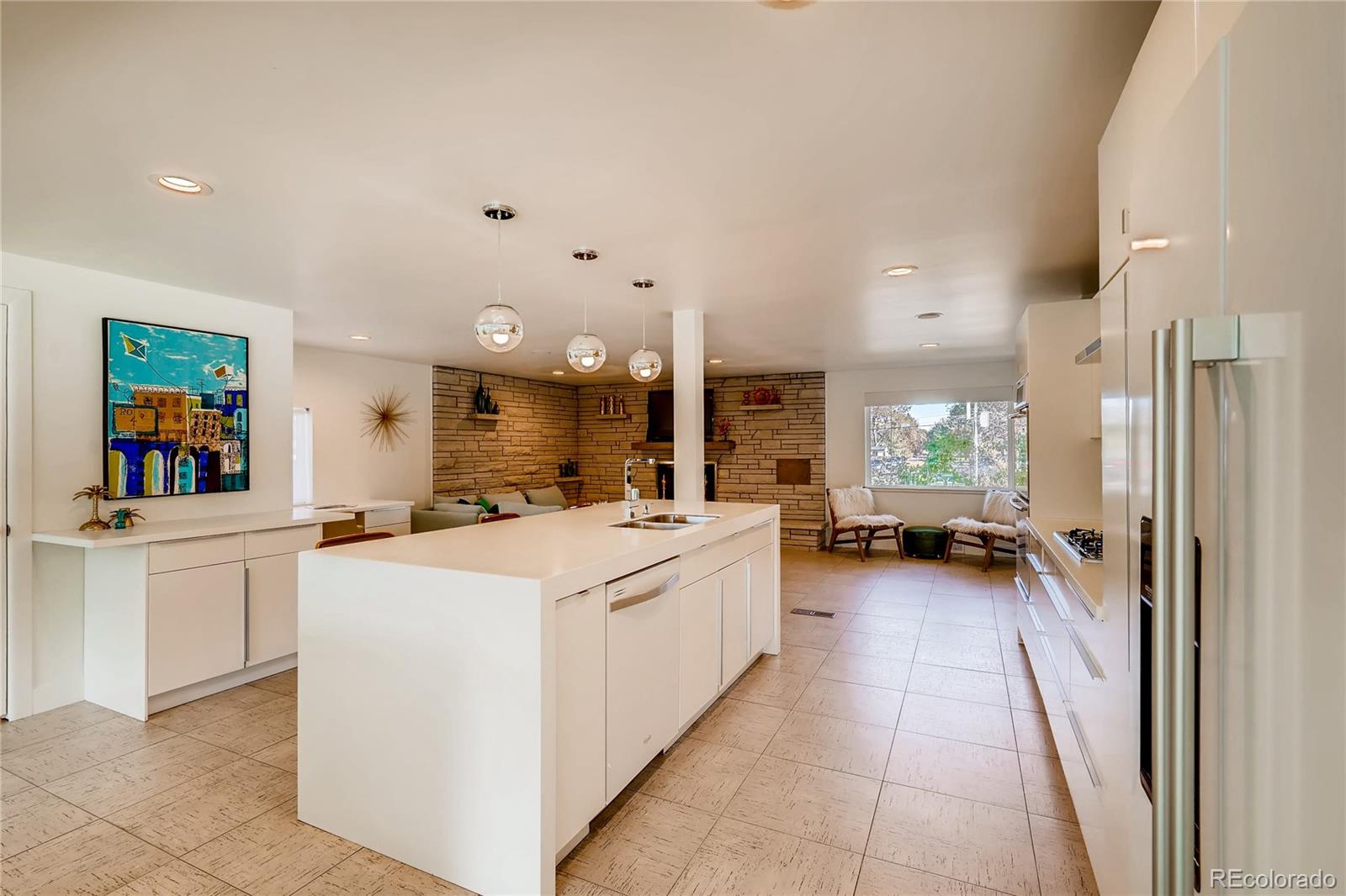 4295 North Harlan Street Wheat Ridge, CO 80033 - Photo 13 of 30 a kitchen that has a lot of white cabinets and a wooden floor