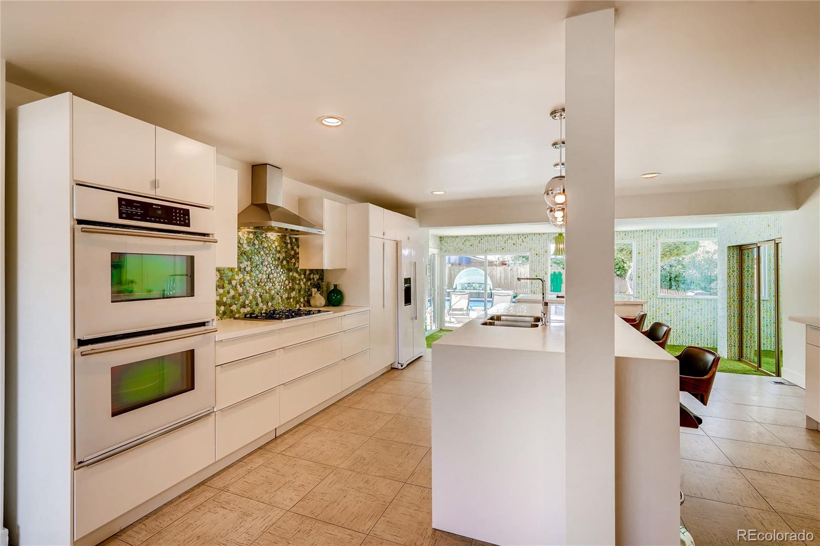 4295 North Harlan Street Wheat Ridge, CO 80033 - Photo 15 of 30 a kitchen with stainless steel appliances kitchen island granite countertop a refrigerator and a stove