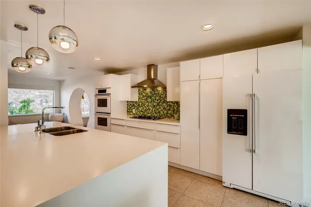 a kitchen with stainless steel appliances granite countertop a stove a refrigerator and a microwave
