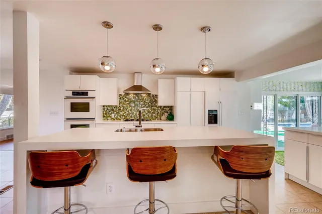 a kitchen with stainless steel appliances kitchen island granite countertop a table and chairs in it