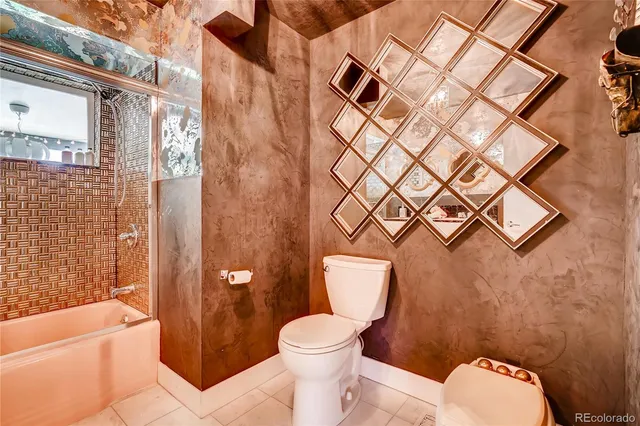 a white toilet sitting next to a bathroom sink and tub
