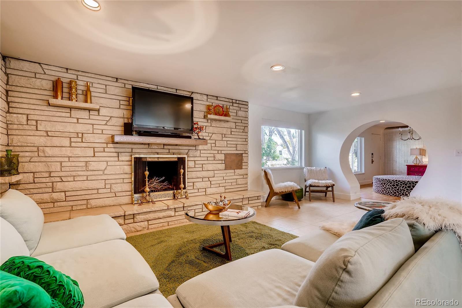 4295 North Harlan Street Wheat Ridge, CO 80033 - Photo 10 of 30 a living room with furniture a flat screen tv and a fireplace