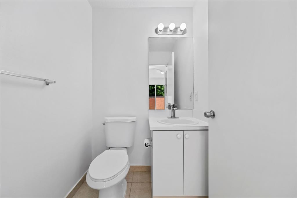 717 Southwest 107th Avenue, Unit 2203 Pembroke Pines, FL 33025 - Photo 20 of 22 a bathroom with a toilet a sink and mirror