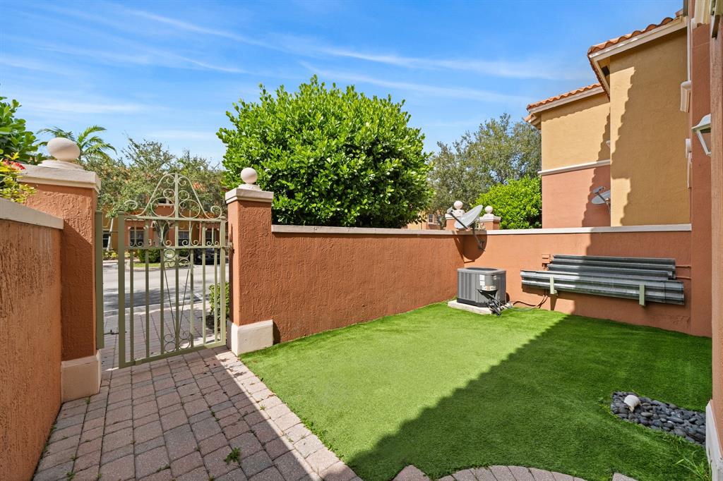 717 Southwest 107th Avenue, Unit 2203 Pembroke Pines, FL 33025 - Photo 22 of 22 a backyard of a house with table and chairs