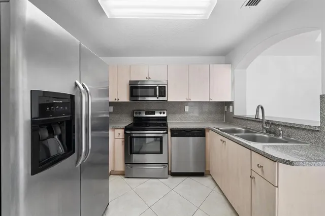 a kitchen with stainless steel appliances granite countertop a refrigerator a stove a sink and a granite counter tops