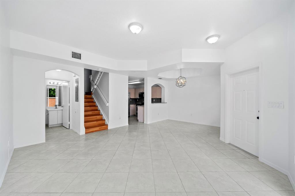 717 Southwest 107th Avenue, Unit 2203 Pembroke Pines, FL 33025 - Photo 10 of 22 an empty room with white walls and stairs