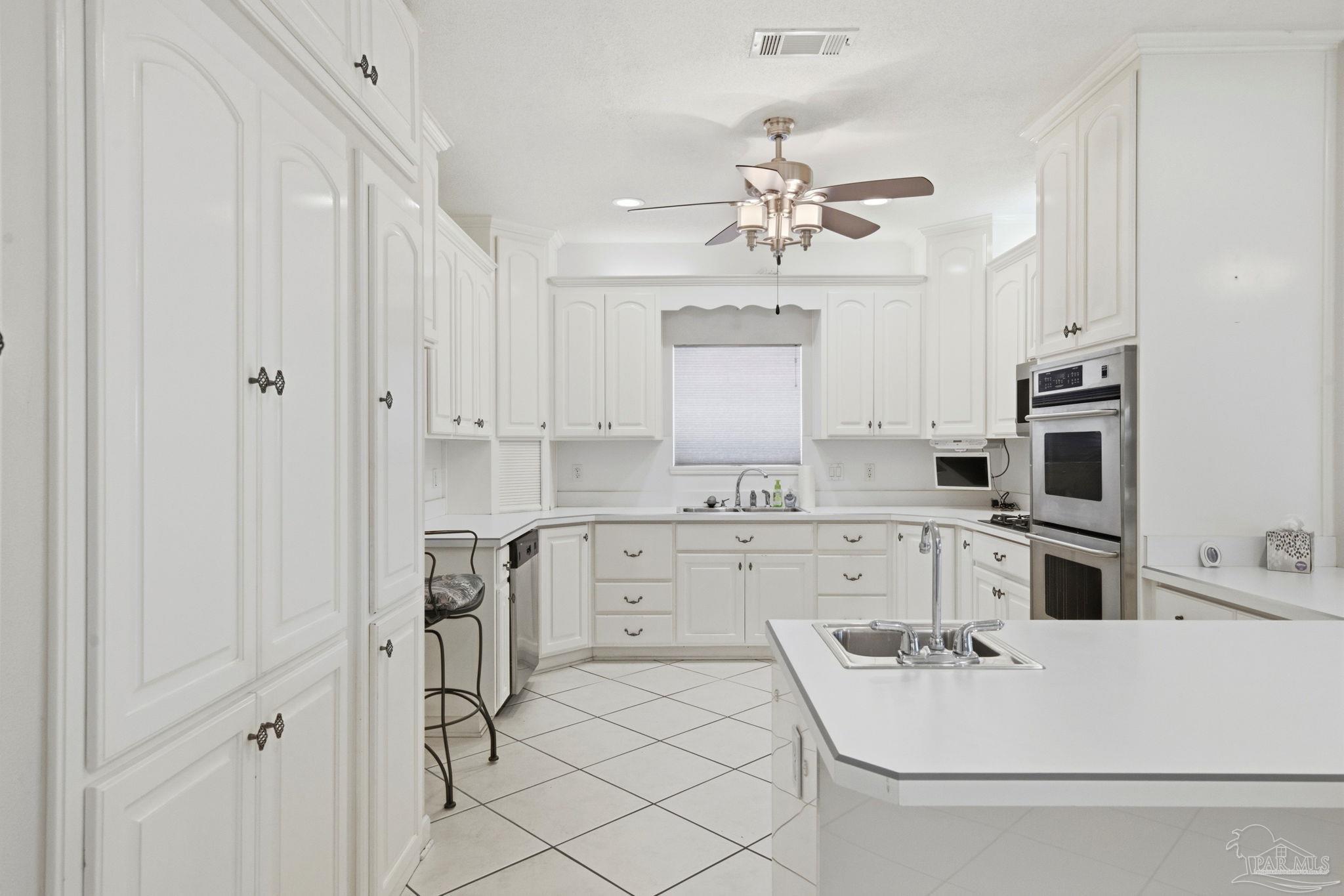 4552 Peaden Road Pace, FL 32571 - Photo 20 of 38 a kitchen with white cabinets and white appliances
