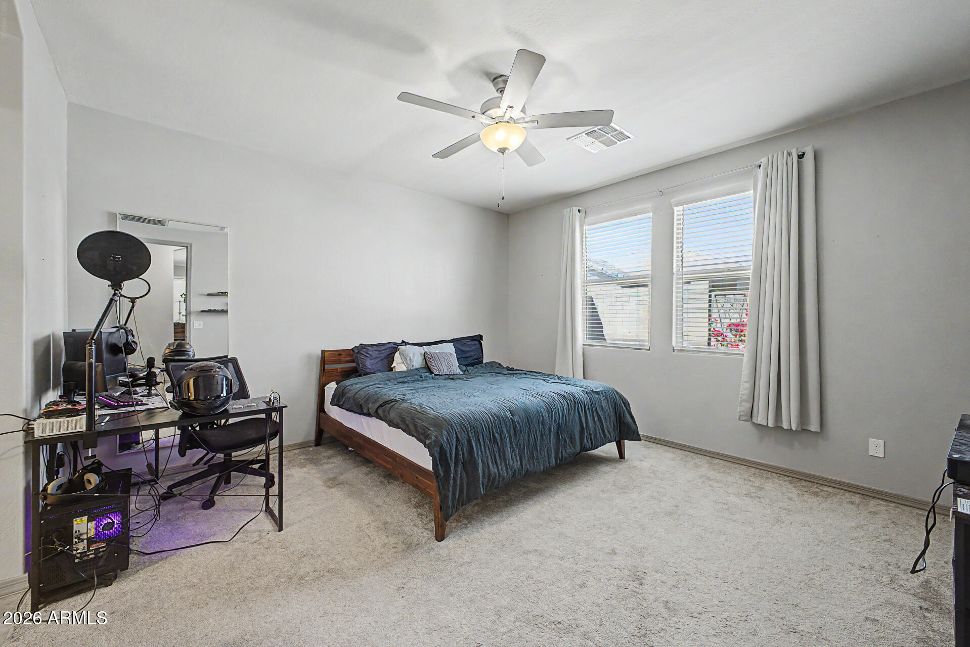 15088 West Garfield Street Goodyear, AZ 85338 - Photo 12 of 31 a spacious bedroom with a bed and a chandelier
